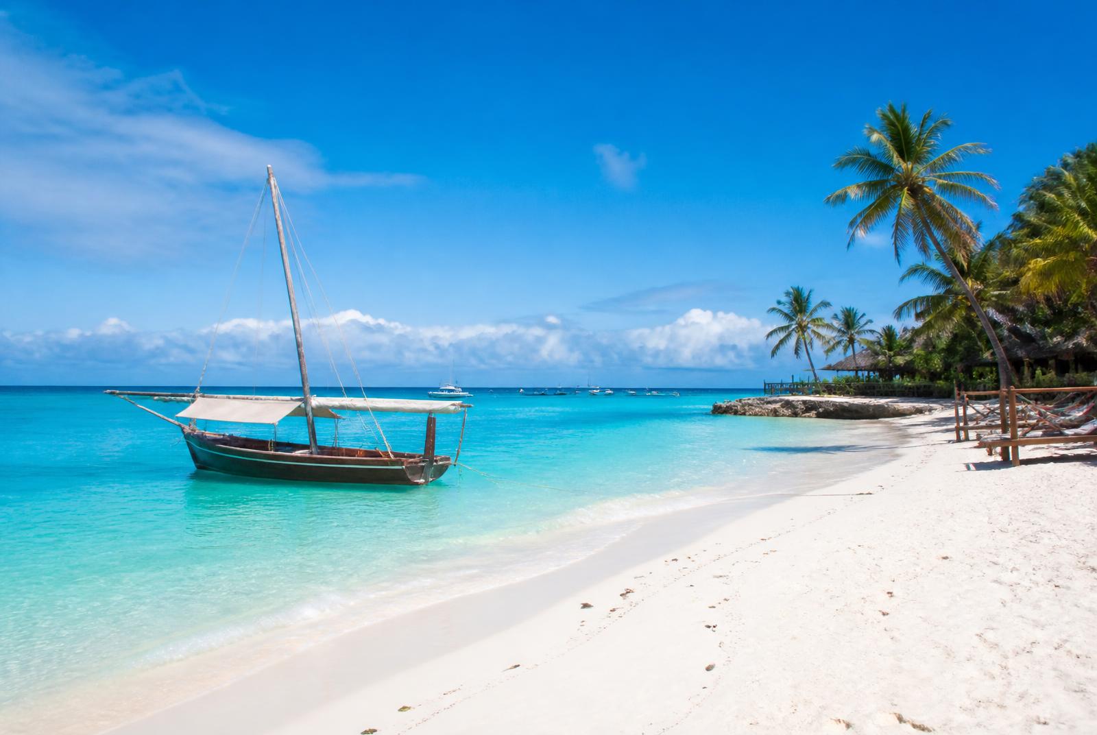 Zanzibar beach with a traditional dhow on turquoise water